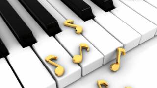 Pianon koskettimien päällä on kultaisia nuottiavaimia.