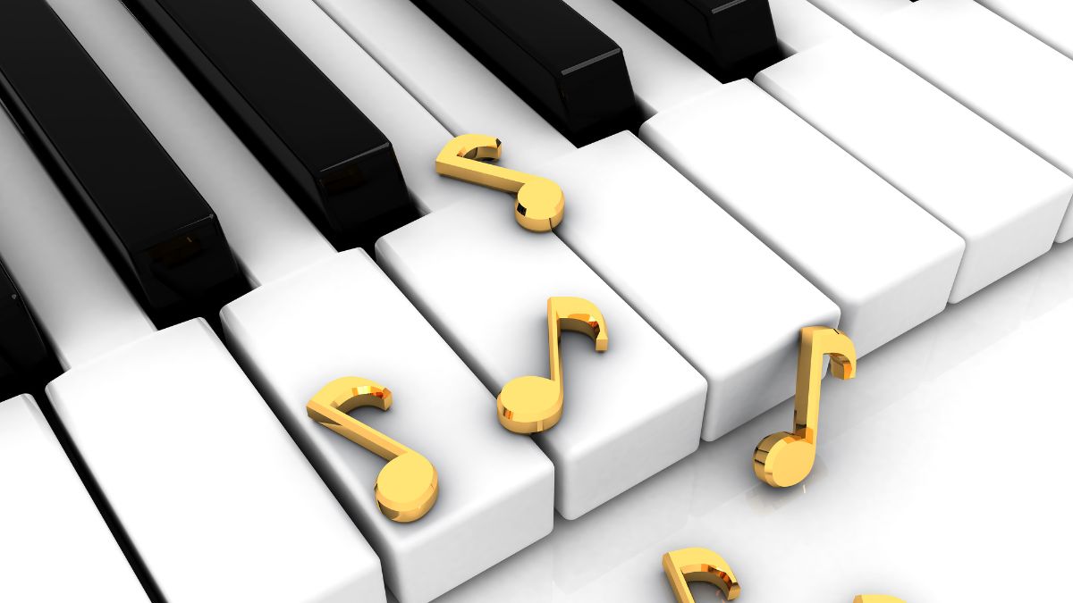 Pianon koskettimien päällä on kultaisia nuottiavaimia.