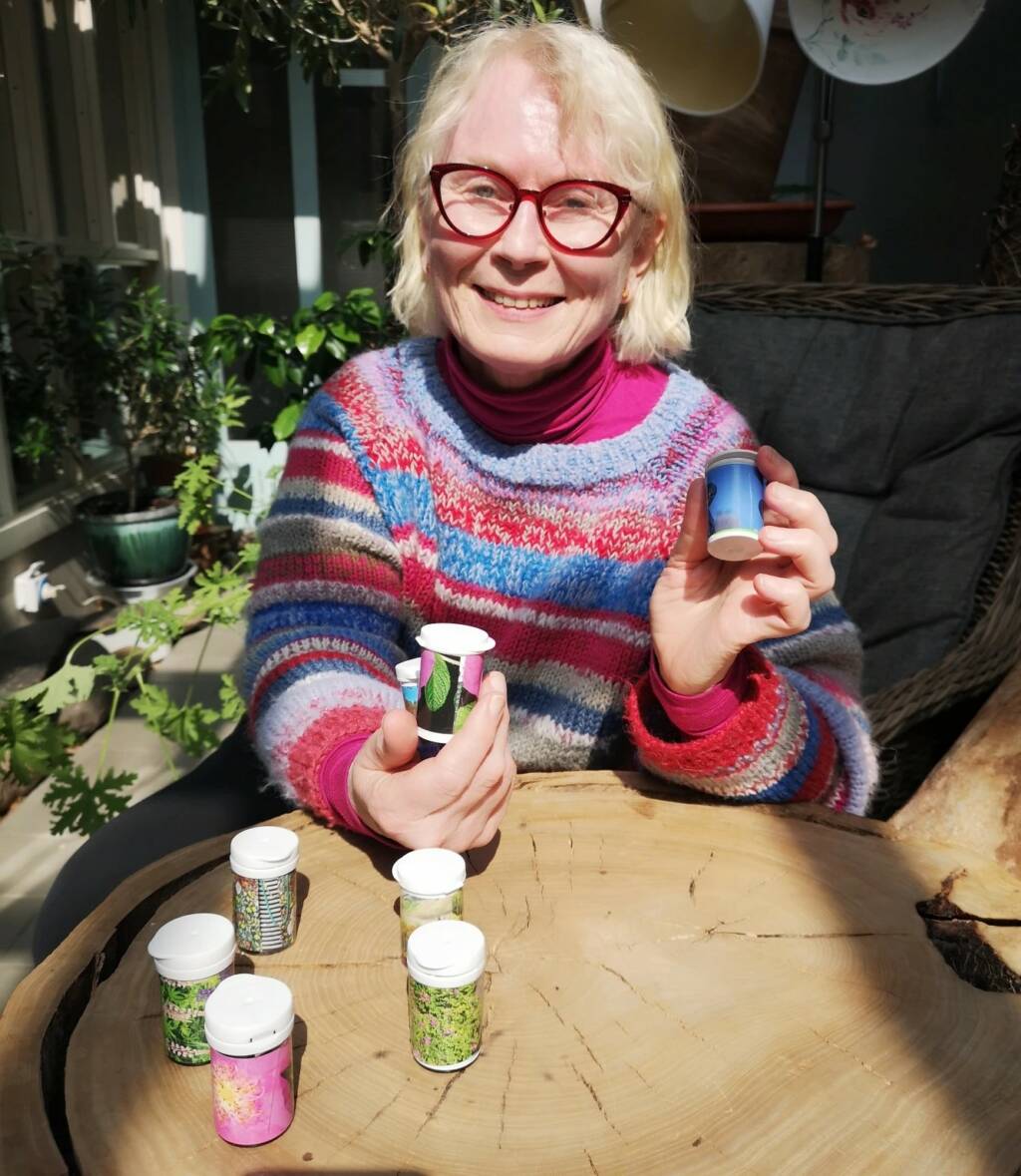 Nainen pitelee käsissään pieniä purkkeja.