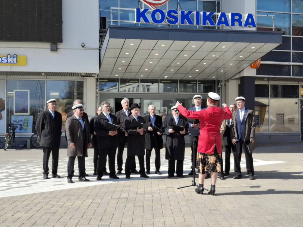 Valkeakosken mieslaulajat esiintyvät liikekeskus Koskikaran edessä.