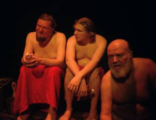 Kolme miestä istuu saunan lauteilla.