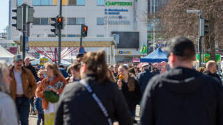Ihmisiä kävelemässä Valkeakosken keskustassa vappuna ja odottamassa liikennevaloissa.