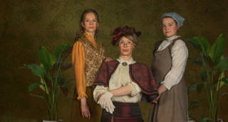 Kolme naista vanhanaikaisesti pukeutuneena.