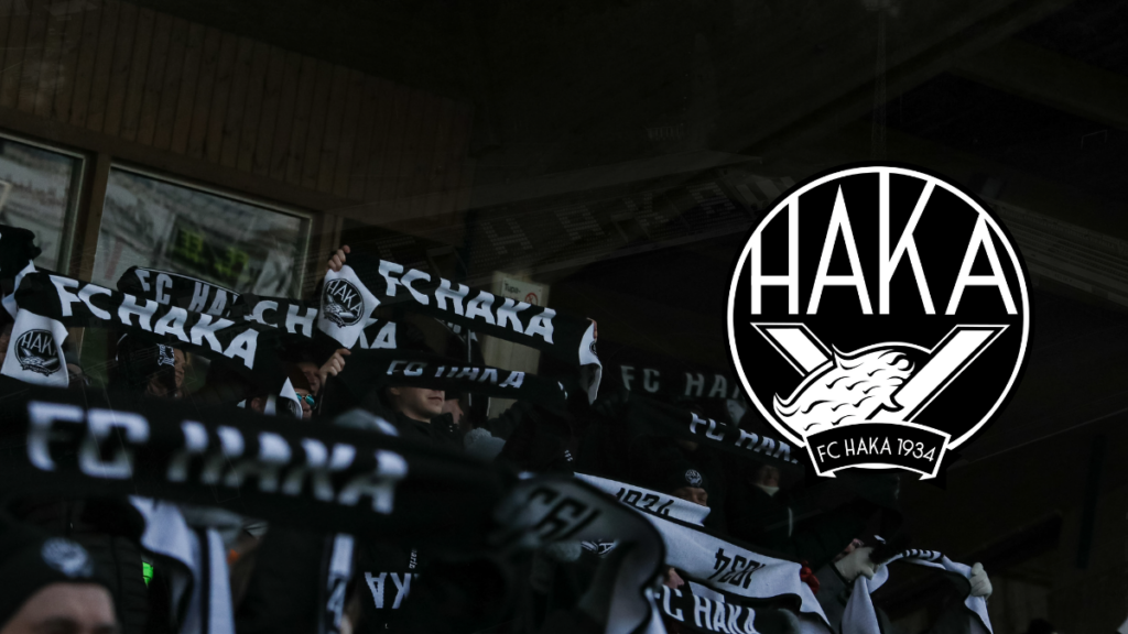 Jalkapalloyleisöllä on FC Hakan huiveja ja oikealla on FC Hakan logo.