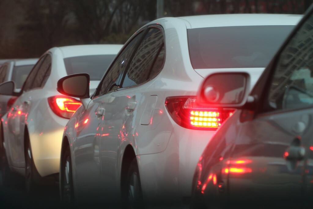 Useita autoja lähellä toisiaan jonossa liikenteessä.
