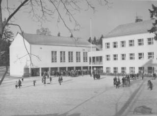 Mustavalkoinen kuva vanhasta koulurakennuksesta.